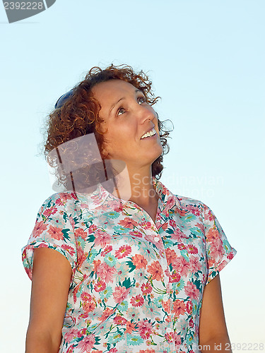 Image of Joyful woman against blue sky