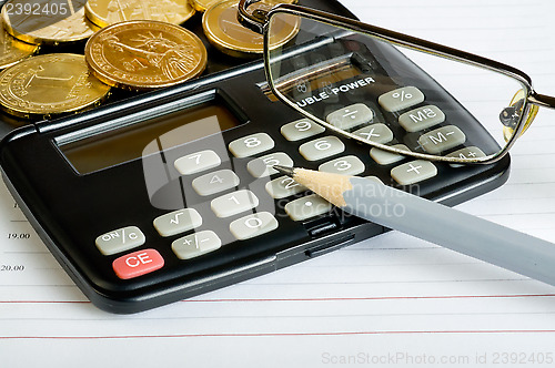 Image of Calculator, glasses, coins and pencil