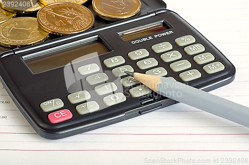 Image of Calculator, coins and pencil