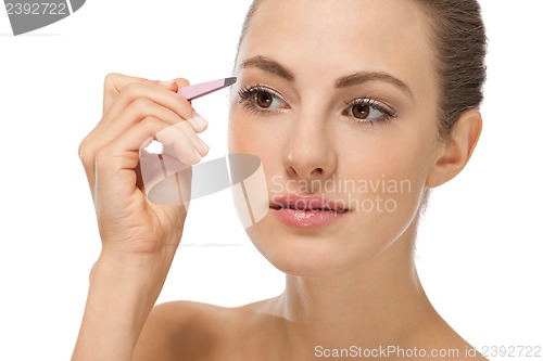 Image of beautiful young woman and eyebrow tweezers 
