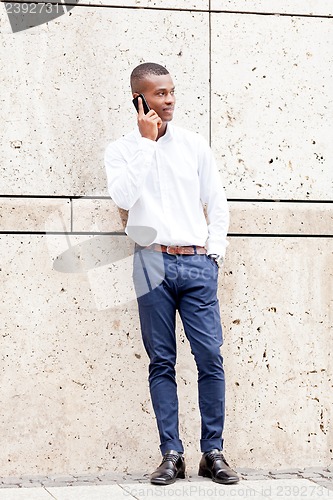 Image of young successfil african businessman with mobilephone 