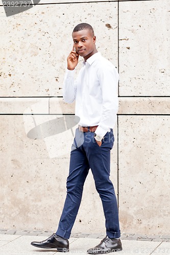 Image of young successfil african businessman with mobilephone 