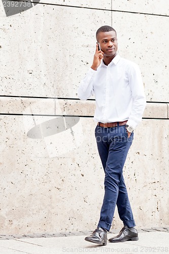 Image of young successfil african businessman with mobilephone 