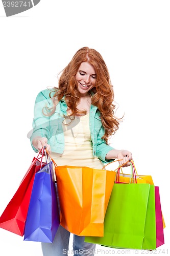 Image of smiling young redhead girl with colorful shoppingbags 