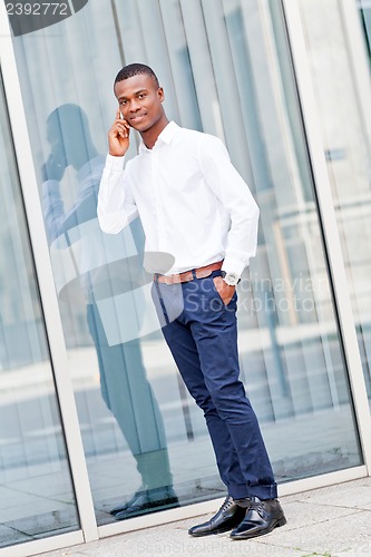 Image of young successfil african businessman with mobilephone 