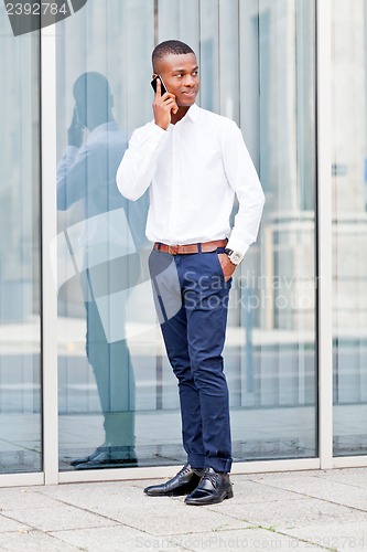 Image of young successfil african businessman with mobilephone 