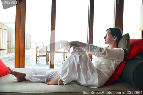 Image of happy young woman relax at home on sofa