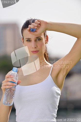 Image of Young beautiful woman drinking water after fitness exercise