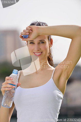 Image of Young beautiful woman drinking water after fitness exercise