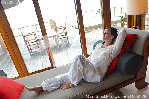 Image of happy young woman relax at home on sofa