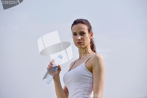 Image of Young beautiful woman drinking water after fitness exercise