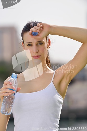 Image of Young beautiful woman drinking water after fitness exercise