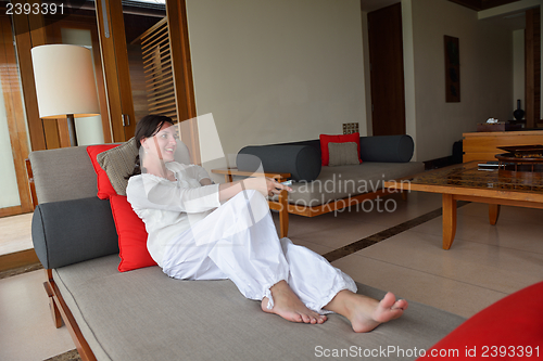 Image of happy young woman relax at home on sofa