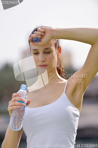 Image of Young beautiful woman drinking water after fitness exercise