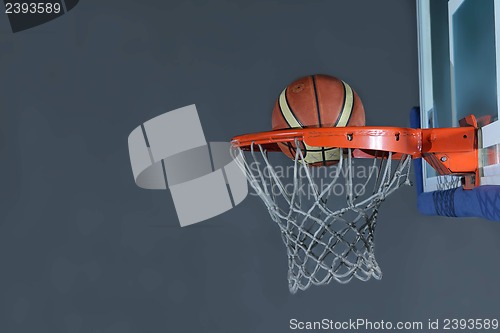 Image of basketball ball and net on grey background