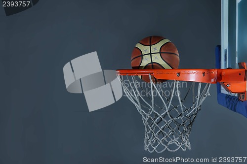 Image of basketball ball and net on grey background