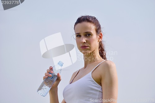 Image of Young beautiful woman drinking water after fitness exercise
