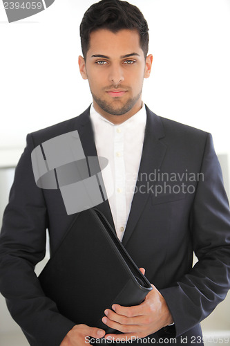 Image of Serious young businessman with a folder