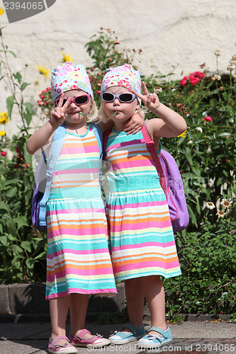 Image of Cute little twin girls making V-signs