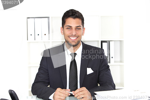 Image of Handsome smiling businessman at his desk