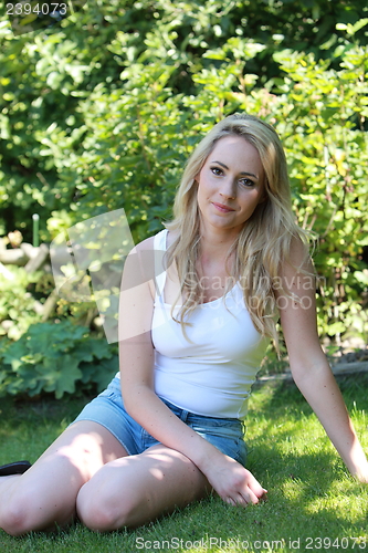 Image of Pretty blond woman relaxing in her garden