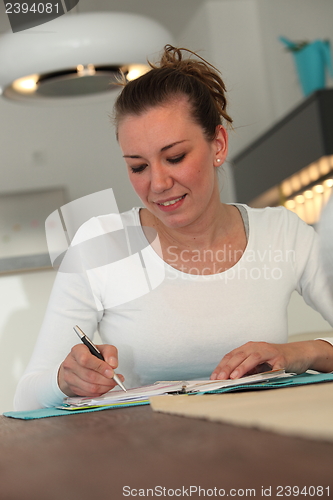 Image of Young woman working at home at a table