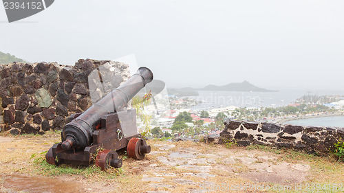 Image of Very old rusted canon pointing at a bay