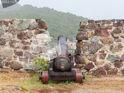Image of Very old rusted canon on top of an old wall