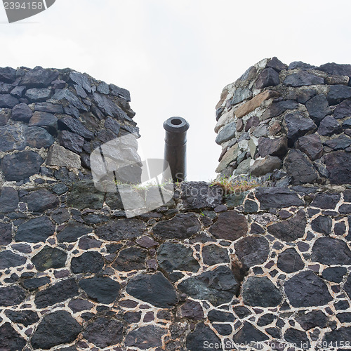 Image of Very old rusted canon on top of an old wall