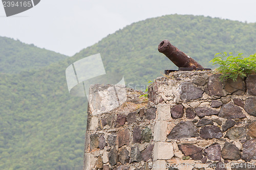Image of Very old rusted canon on top of an old wall