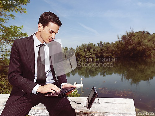 Image of businessman using laptop outdoors b