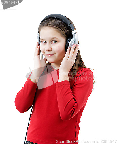 Image of A smiling child girl listens to music through headphones