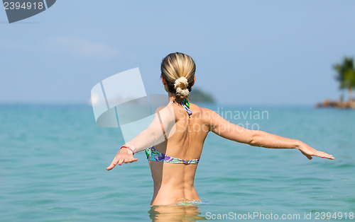 Image of Beautiful young slim girl in the water in the sea, looking away