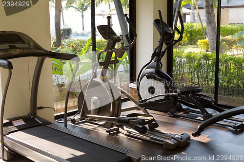 Image of gym with jogging simulators with windows on the tropics