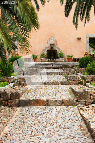 Image of Cobbled walkway leading to a garden fountain