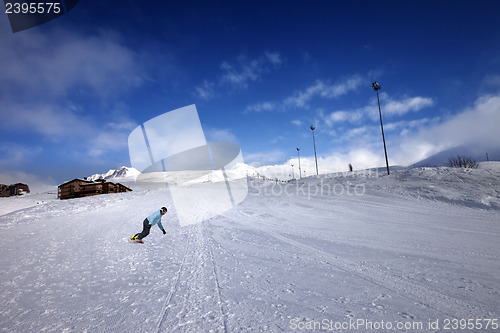Image of Hotel in winter mountains and snowboarder on slope