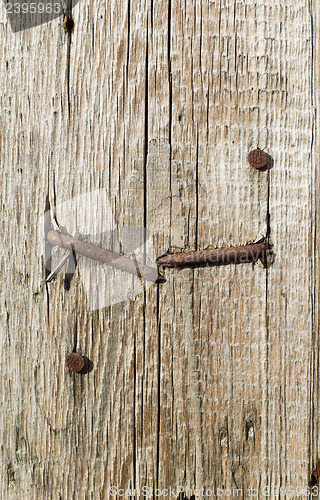 Image of textured surface of board with a rusty nail