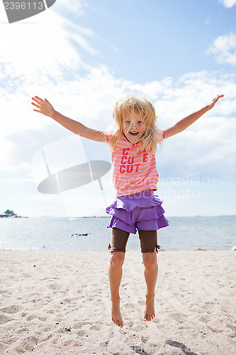 Image of Young girl jumping at beach