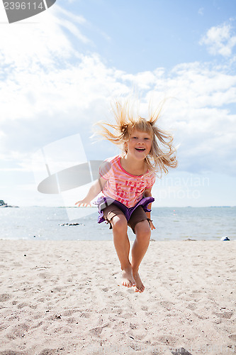 Image of Young girl jumping at beach