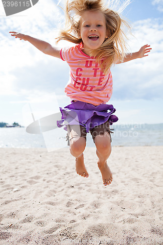 Image of Young girl jumping at beach