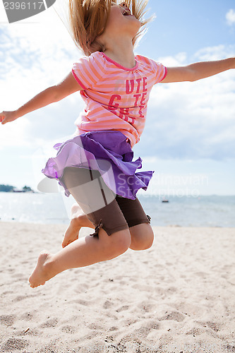 Image of Young girl jumping at beach