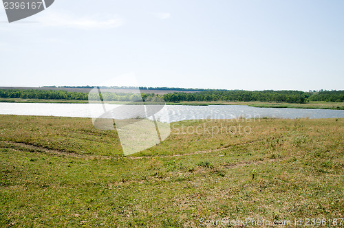 Image of view to green meadow and little pond