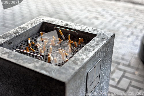 Image of Cigarettes in a public ashtray