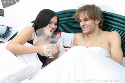 Image of Couple in bed drinking wine