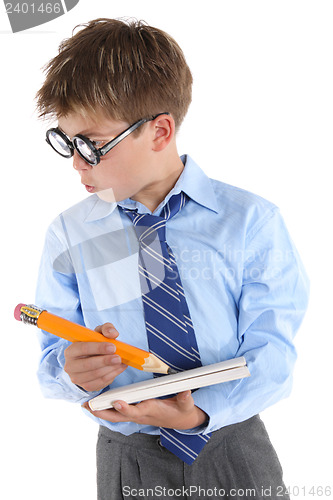 Image of Schoolboy wearing glasses holding book and pencil and looking si
