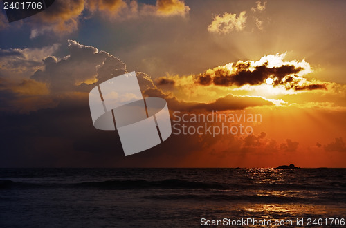Image of Evening landscape with sun and the rays over ocean