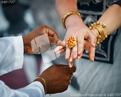 Image of Wedding in Sri Lanka. Ritual - priest ties little fingers with a