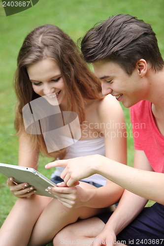 Image of Teenage boy and girl using a tablet-pc