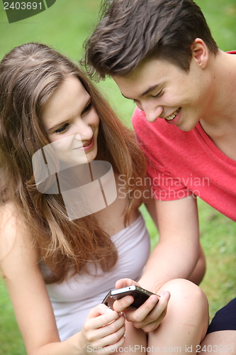Image of Smiling young teenagers using a mobile