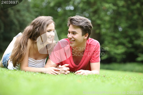 Image of Teenage boy and girl lying on the grass